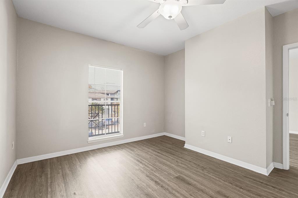 8513 Lucuya Way, Unit 209 Temple Terrace, FL 33637 - Photo 18 of 21 an empty room with wooden floor and windows