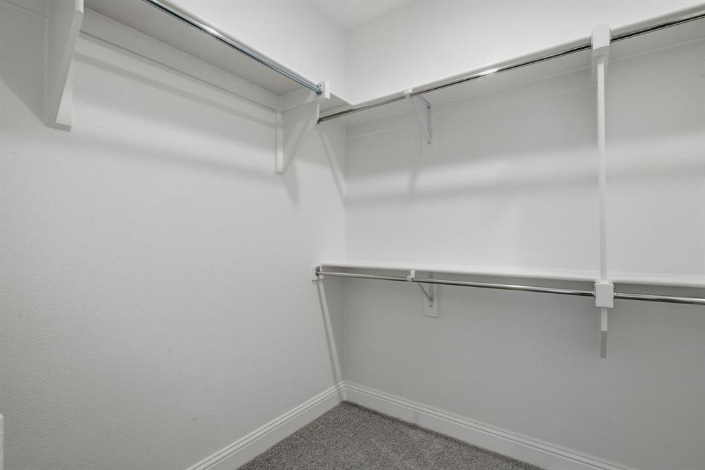 2911 Hanscom Street Forney, TX 75126 - Photo 32 of 40 Walk-in closet featuring white walls, white trim, gray carpet, and a multi-level shelving and hanging system