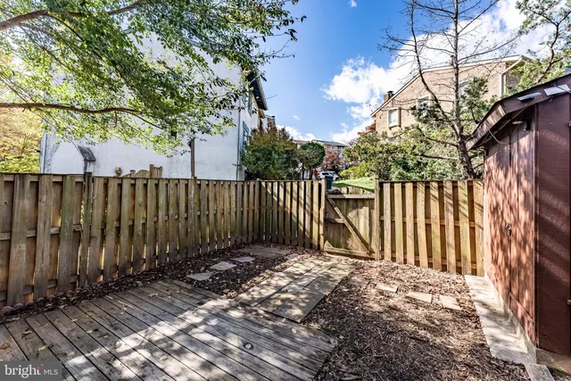 a view of a house with a small yard and wooden fence