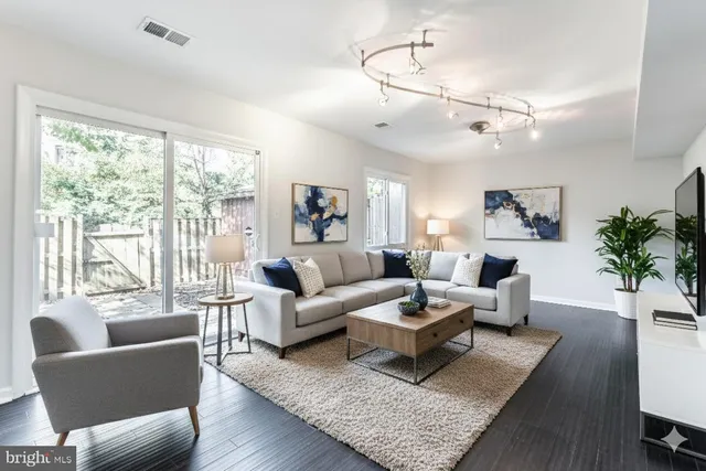 a dining room with wooden floor a chandelier a wooden table and chairs