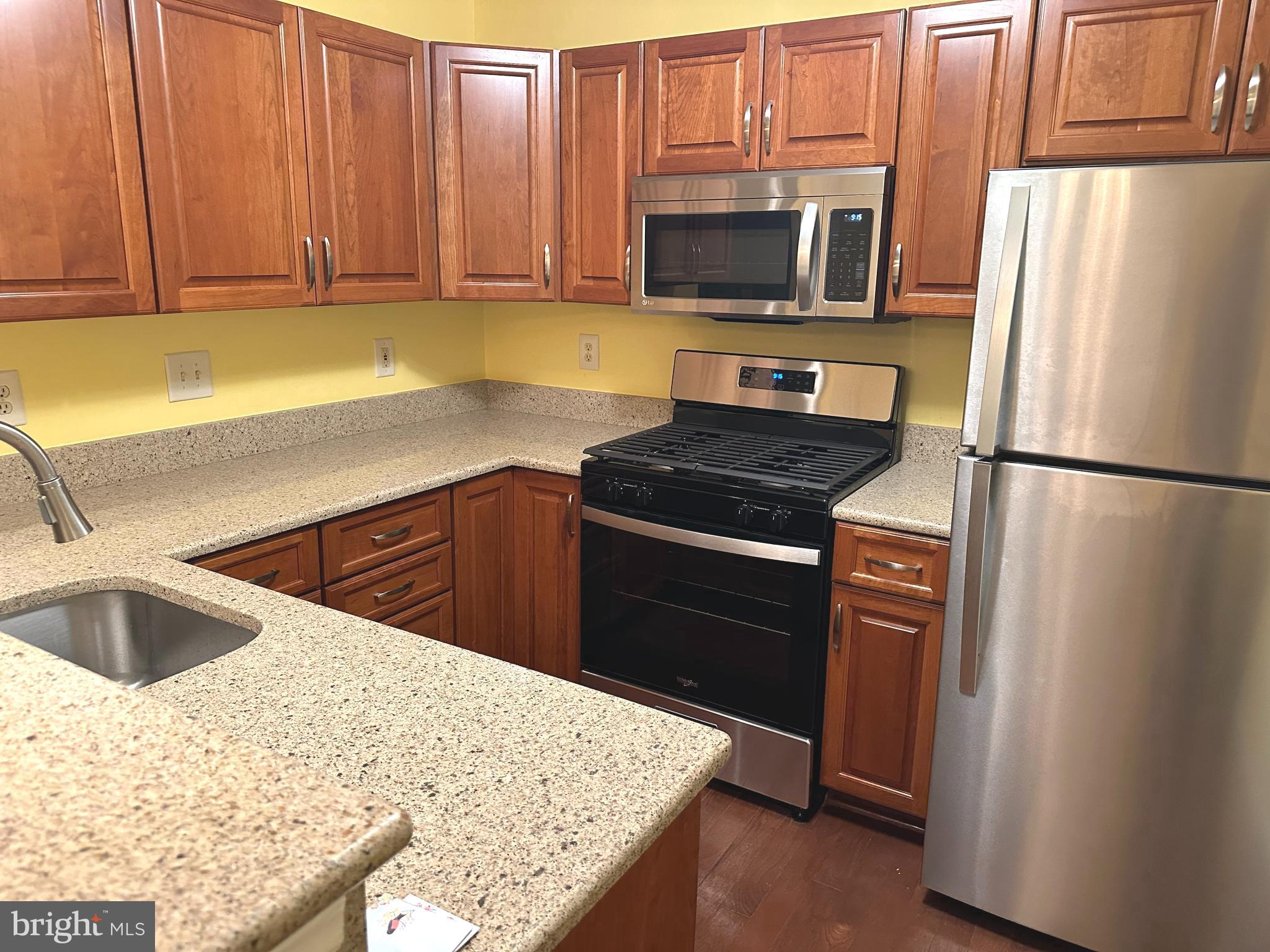 115 Timberbrook Lane, Unit 102 Gaithersburg, MD 20878 - Photo 7 of 20 a kitchen with a sink stove and refrigerator