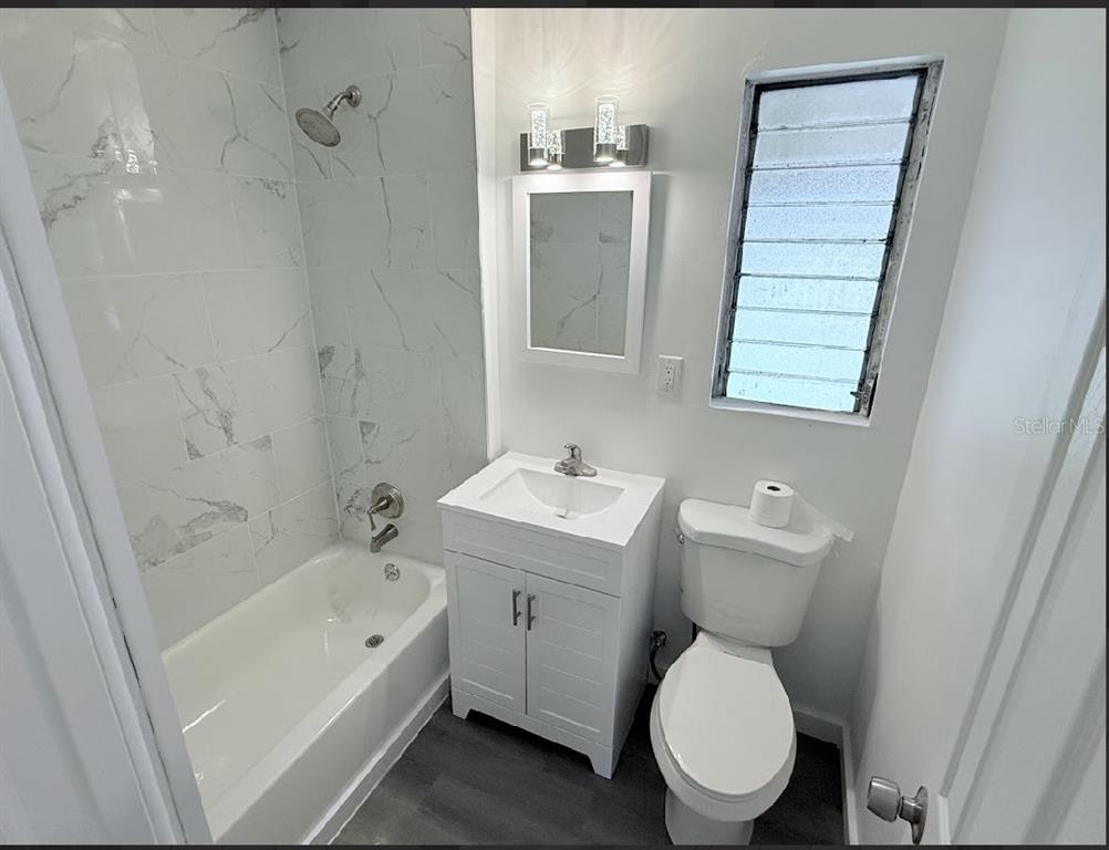 2270 Aaron Street, Unit B Port Charlotte, FL 33952 - Photo 12 of 12 a white toilet sitting next to a bathroom sink and tub