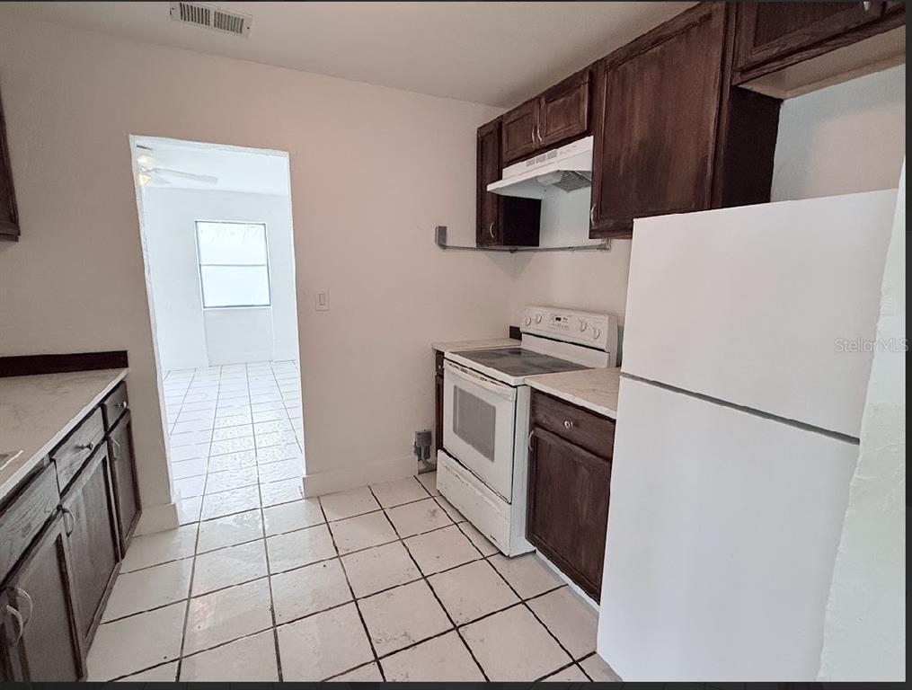 2270 Aaron Street, Unit B Port Charlotte, FL 33952 - Photo 3 of 12 a kitchen with a refrigerator sink and cabinets