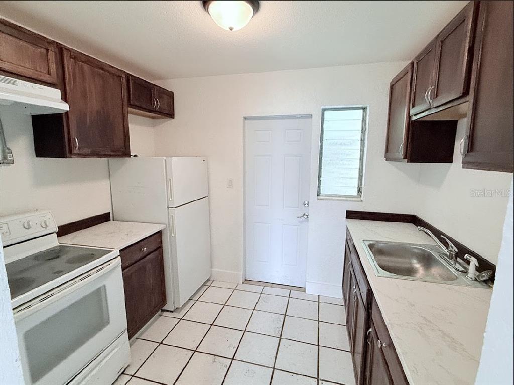 2270 Aaron Street, Unit B Port Charlotte, FL 33952 - Photo 5 of 12 a kitchen with a sink stove and microwave