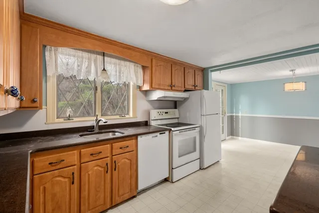 a kitchen with stainless steel appliances granite countertop a sink a stove and a refrigerator