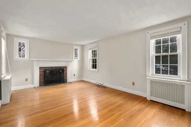 wooden floor fireplace and windows in an empty room