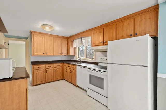 a kitchen with a refrigerator sink and cabinets
