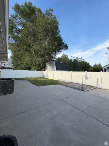1563 South 600 East Springville, UT 84663 - Photo 30 of 30 Rear concrete patio featuring a white privacy fence and a large mature tree