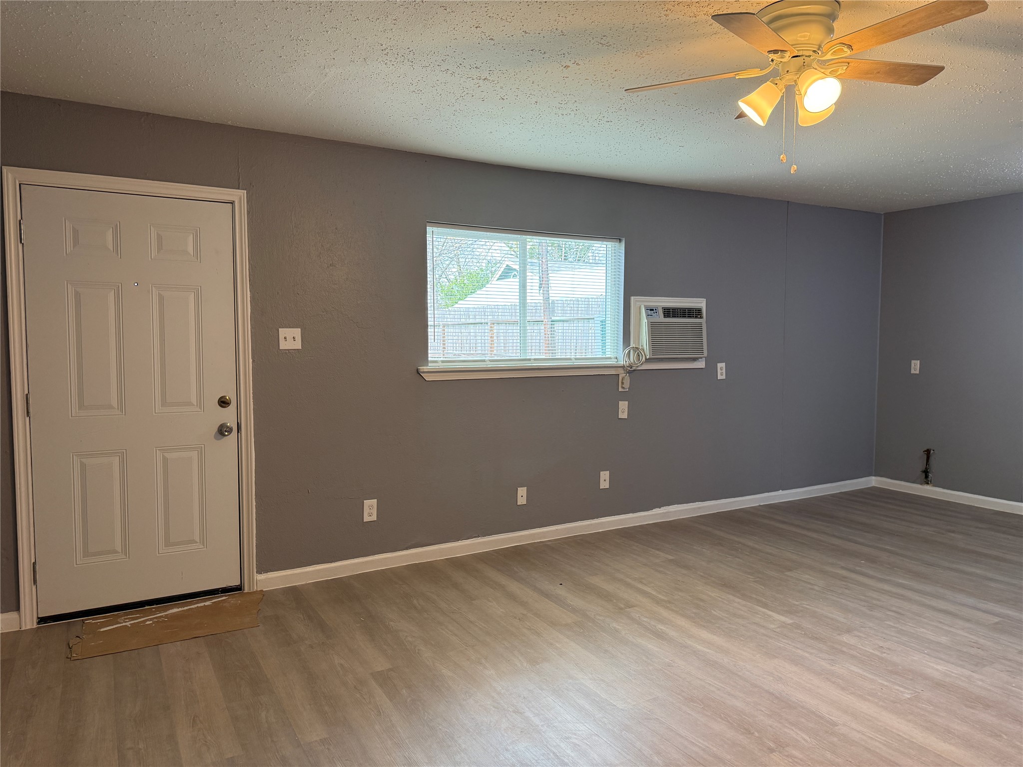 8010 Roswell Street, Unit 3 Houston, TX 77022 - Photo 3 of 12 a view of an empty room with window and wooden floor