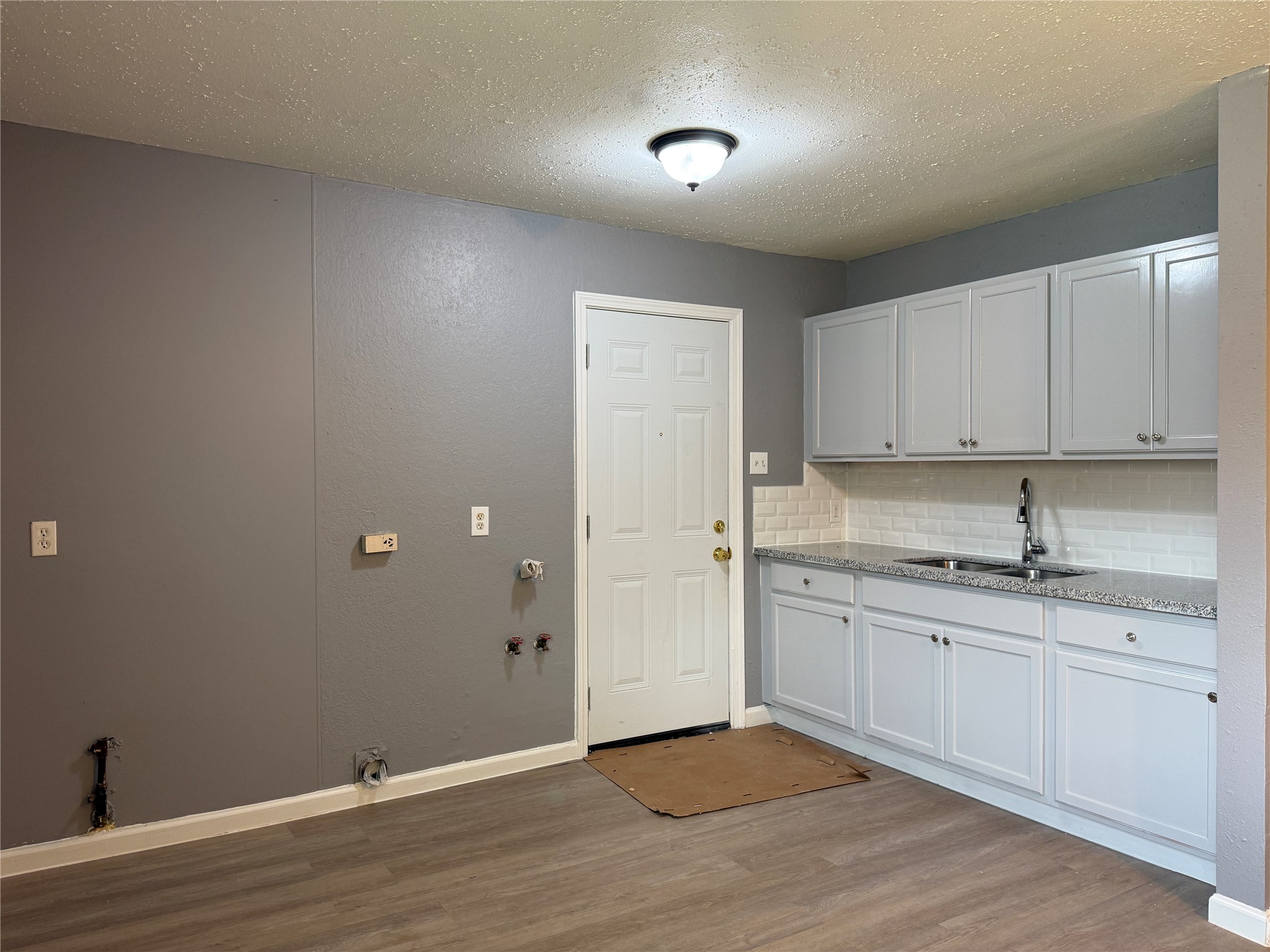 8010 Roswell Street, Unit 3 Houston, TX 77022 - Photo 5 of 12 a view of a kitchen with a sink and dishwasher with wooden floor