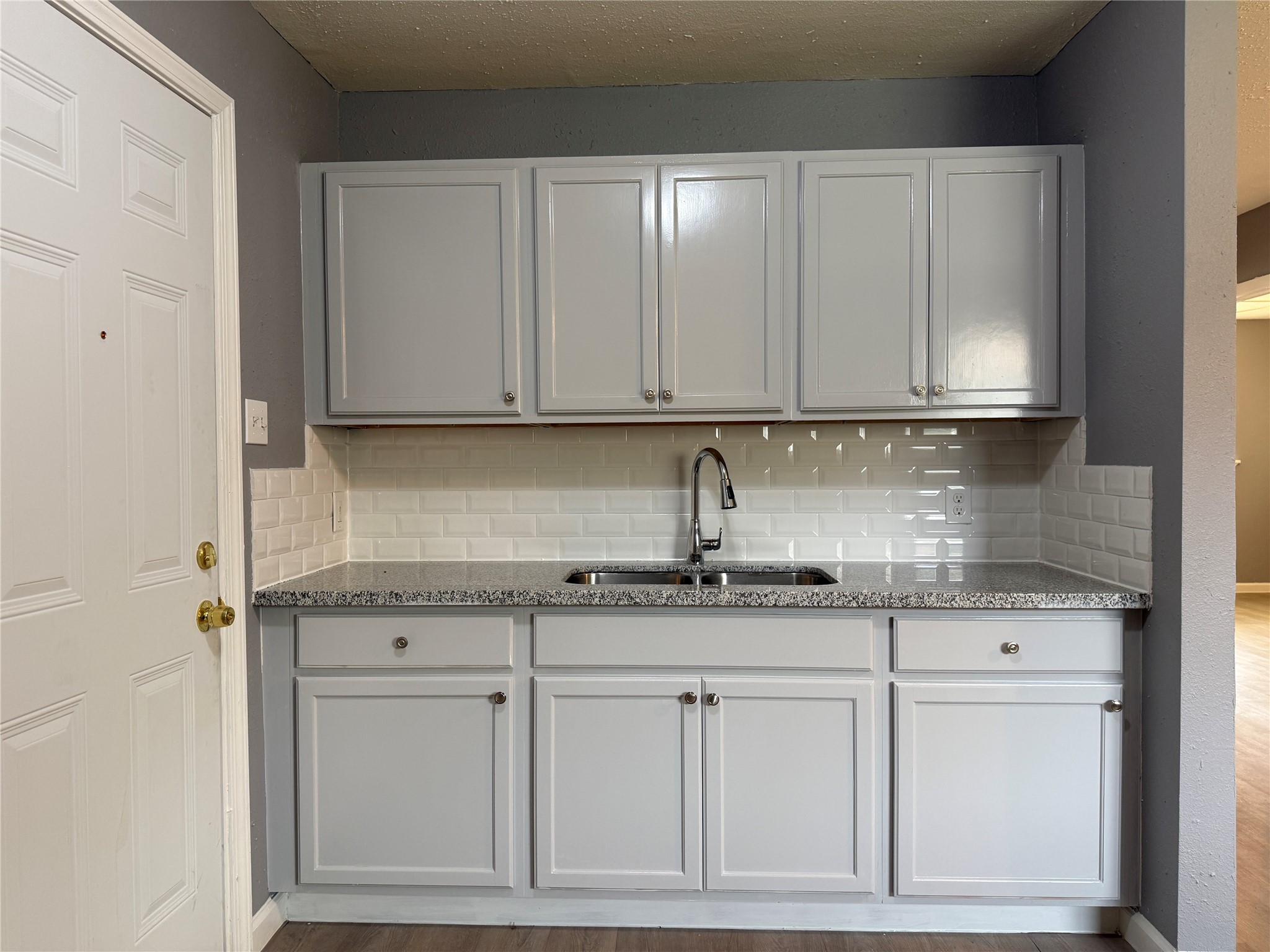 8010 Roswell Street, Unit 3 Houston, TX 77022 - Photo 6 of 12 a kitchen with granite countertop stainless steel appliances white cabinets and a sink