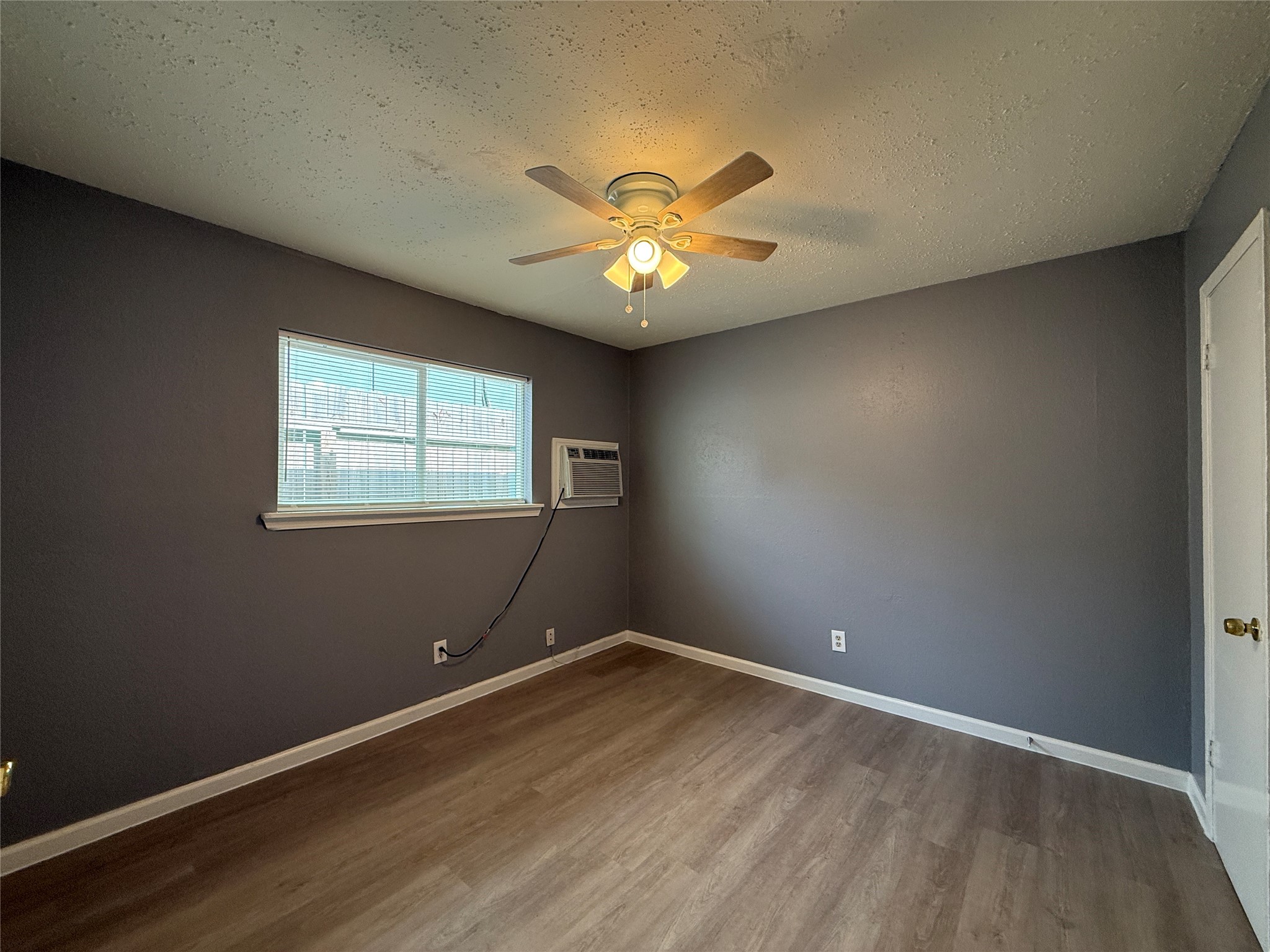 8010 Roswell Street, Unit 3 Houston, TX 77022 - Photo 8 of 12 a view of an empty room with window and wooden floor