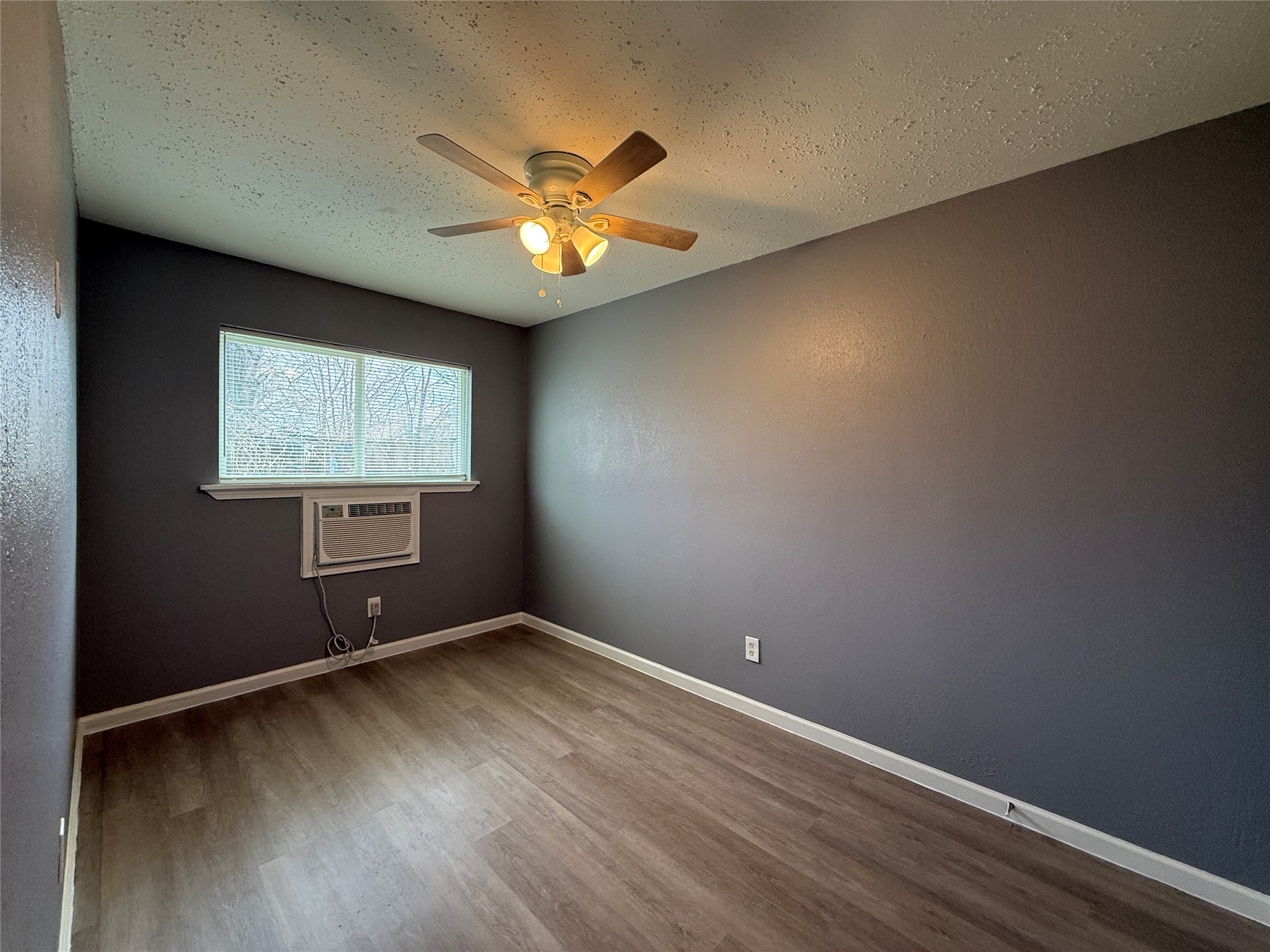 8010 Roswell Street, Unit 3 Houston, TX 77022 - Photo 9 of 12 an empty room with a window and a fan