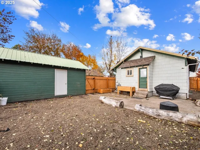 a view of backyard with cabin and wooden fencing