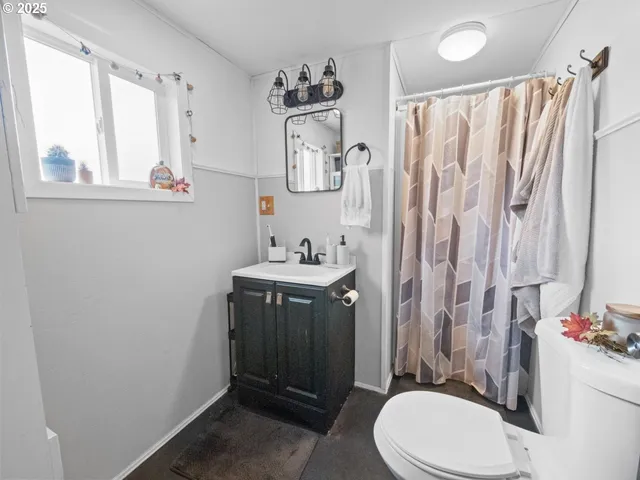 a bathroom with a sink vanity mirror and toilet