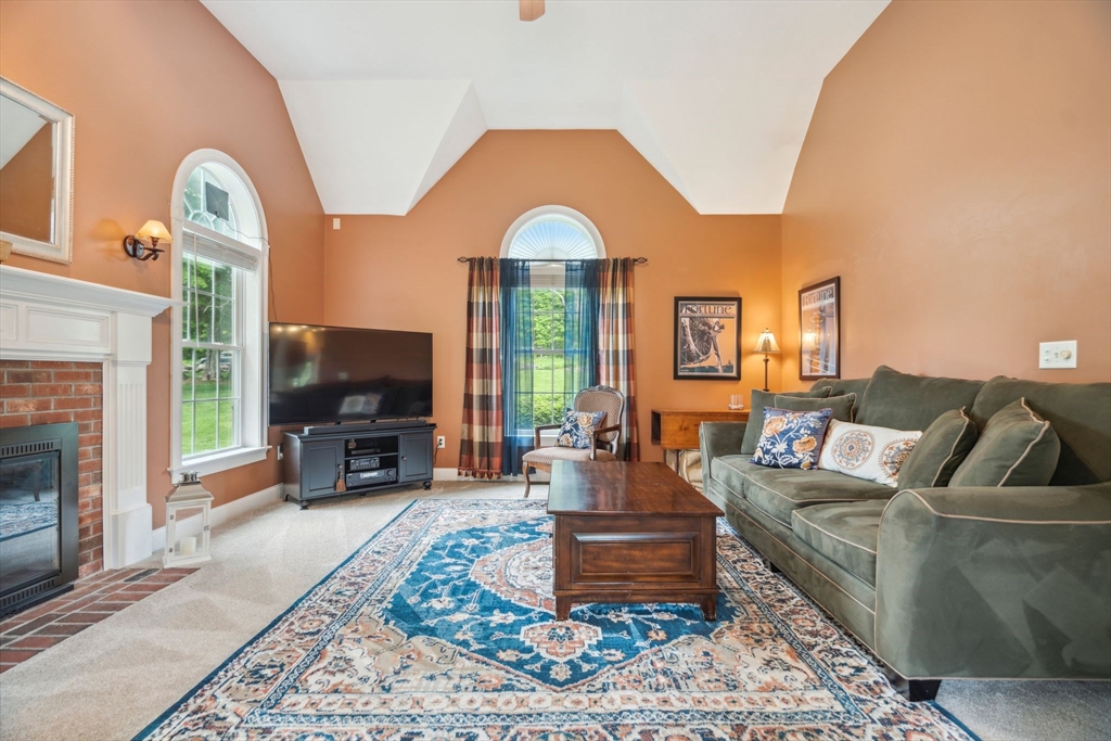 5 Maple Street Pepperell, MA 01463 - Photo 14 of 39 a living room with furniture a fireplace and a flat screen tv