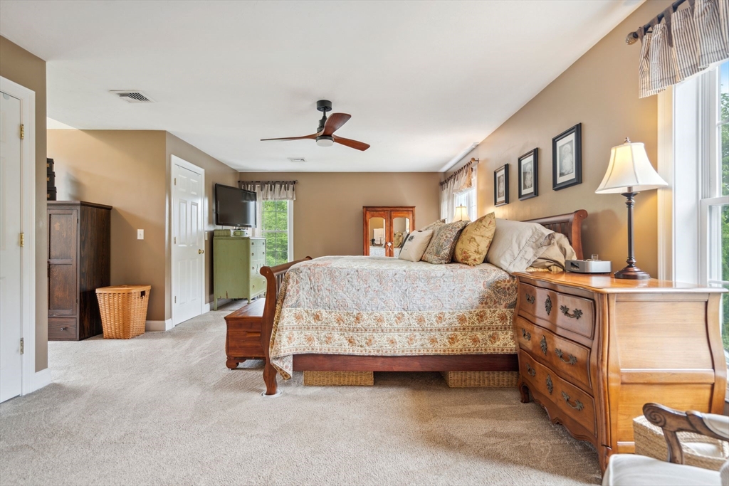 5 Maple Street Pepperell, MA 01463 - Photo 16 of 39 a bedroom with a large bed and a chandelier