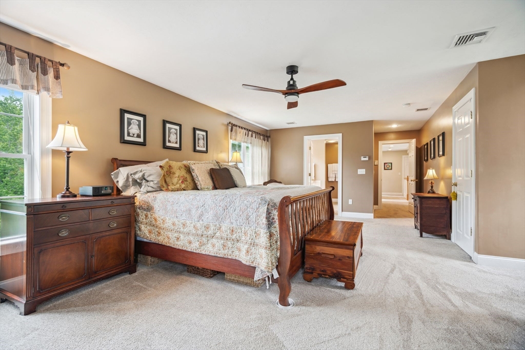 5 Maple Street Pepperell, MA 01463 - Photo 18 of 39 a spacious bedroom with a bed and a chandelier