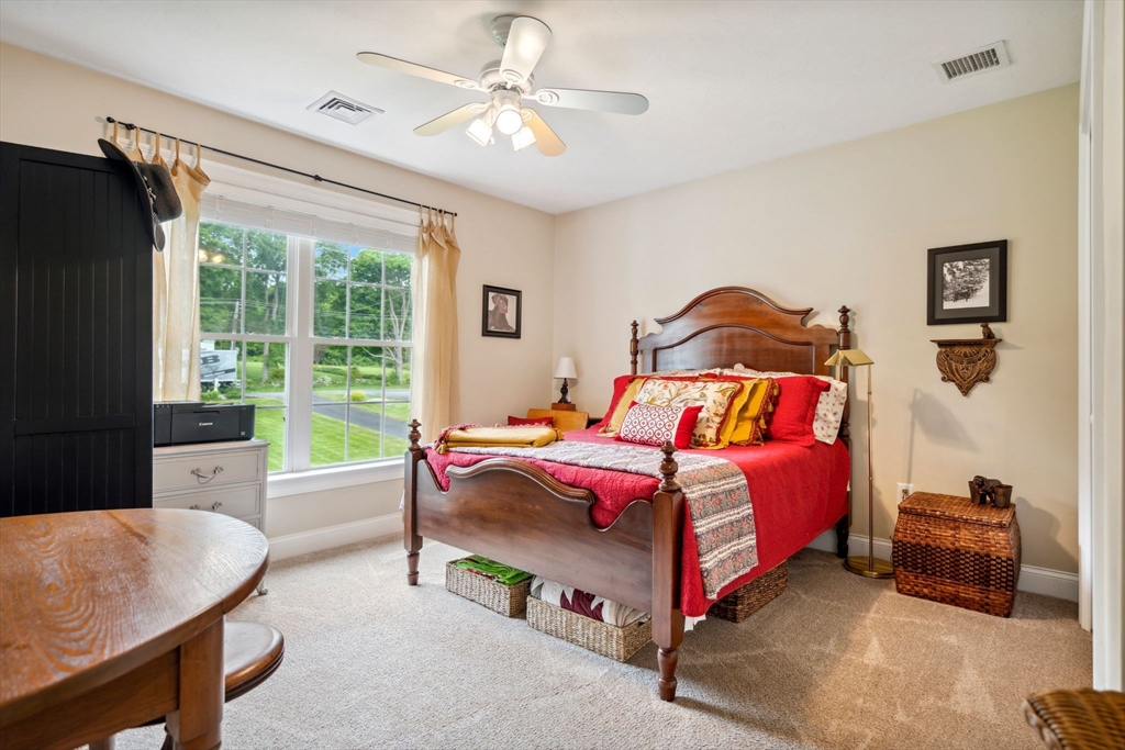 5 Maple Street Pepperell, MA 01463 - Photo 19 of 39 a bedroom with a bed and a chandelier