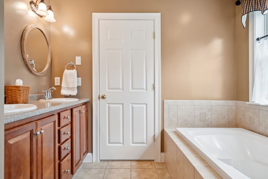 5 Maple Street Pepperell, MA 01463 - Photo 25 of 39 a bathroom with a sink a mirror and a bathtub