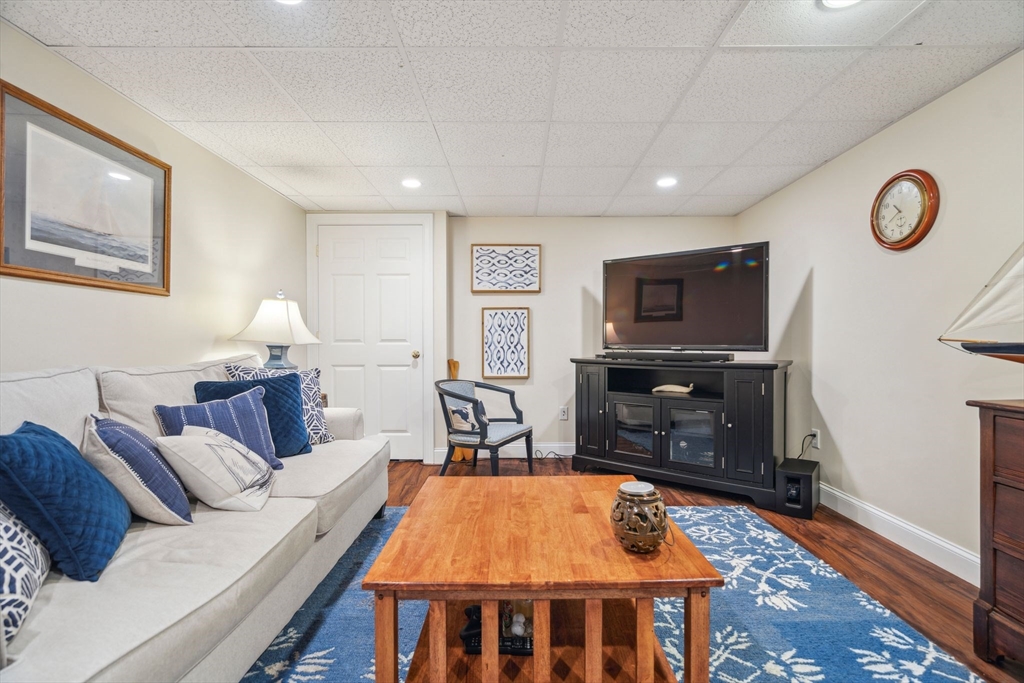 5 Maple Street Pepperell, MA 01463 - Photo 32 of 39 a living room with furniture a flat screen tv and kitchen view