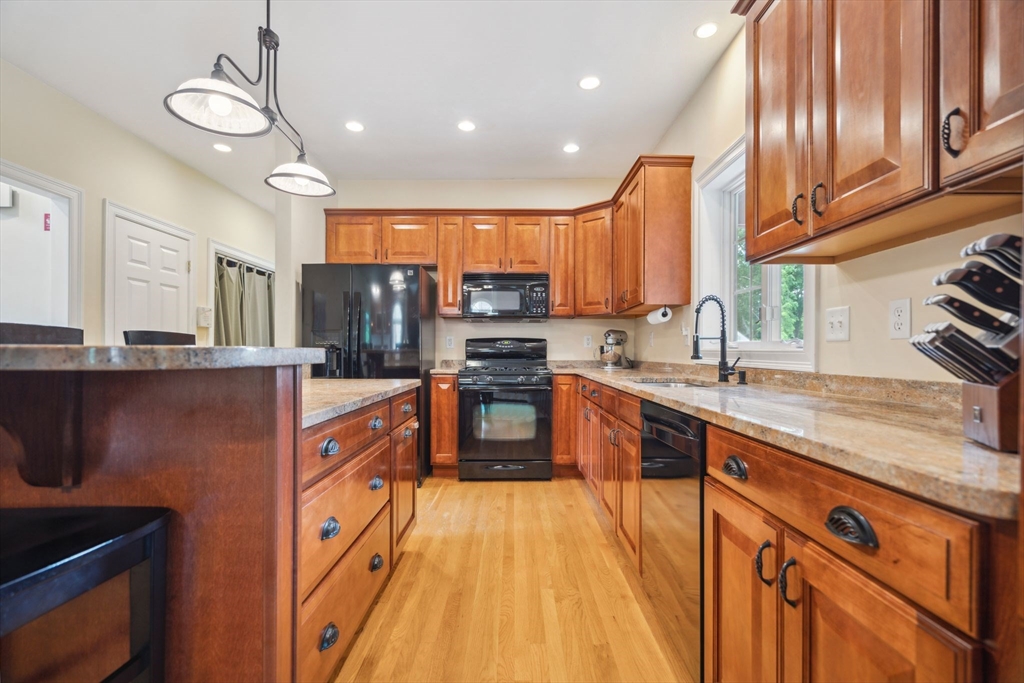 5 Maple Street Pepperell, MA 01463 - Photo 9 of 39 a kitchen with stainless steel appliances granite countertop a sink a stove and a refrigerator