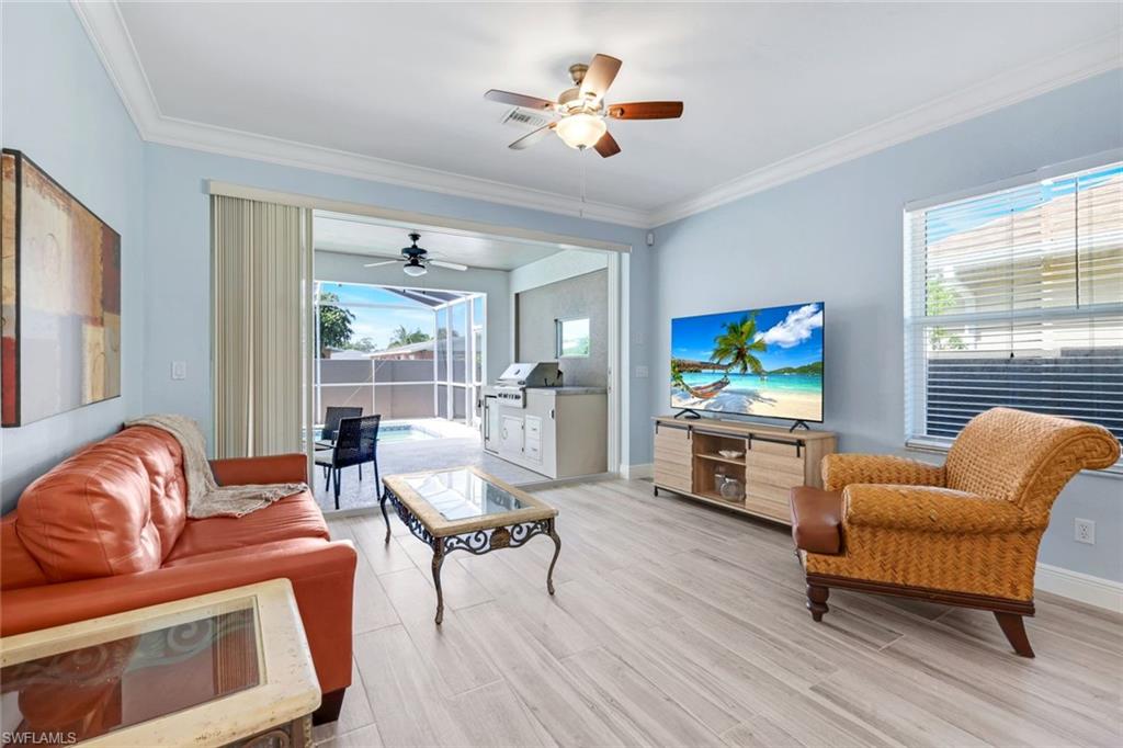 746 101st Avenue North Naples, FL 34108 - Photo 11 of 33 a living room with furniture a flat screen tv and a large window