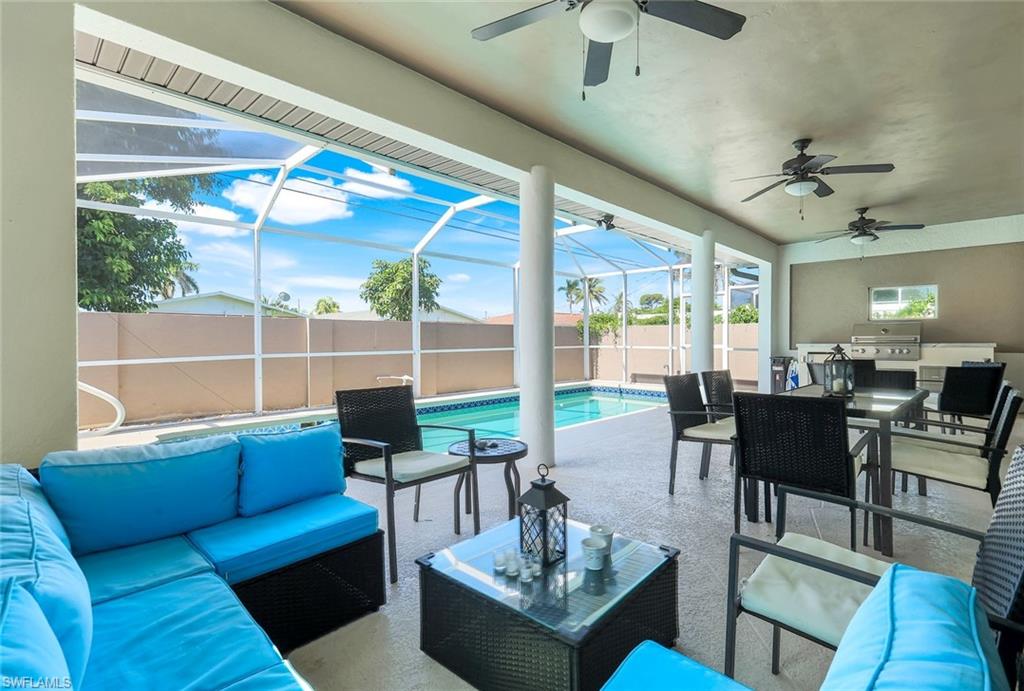 746 101st Avenue North Naples, FL 34108 - Photo 21 of 33 a living room with furniture a flat screen tv and a floor to ceiling window