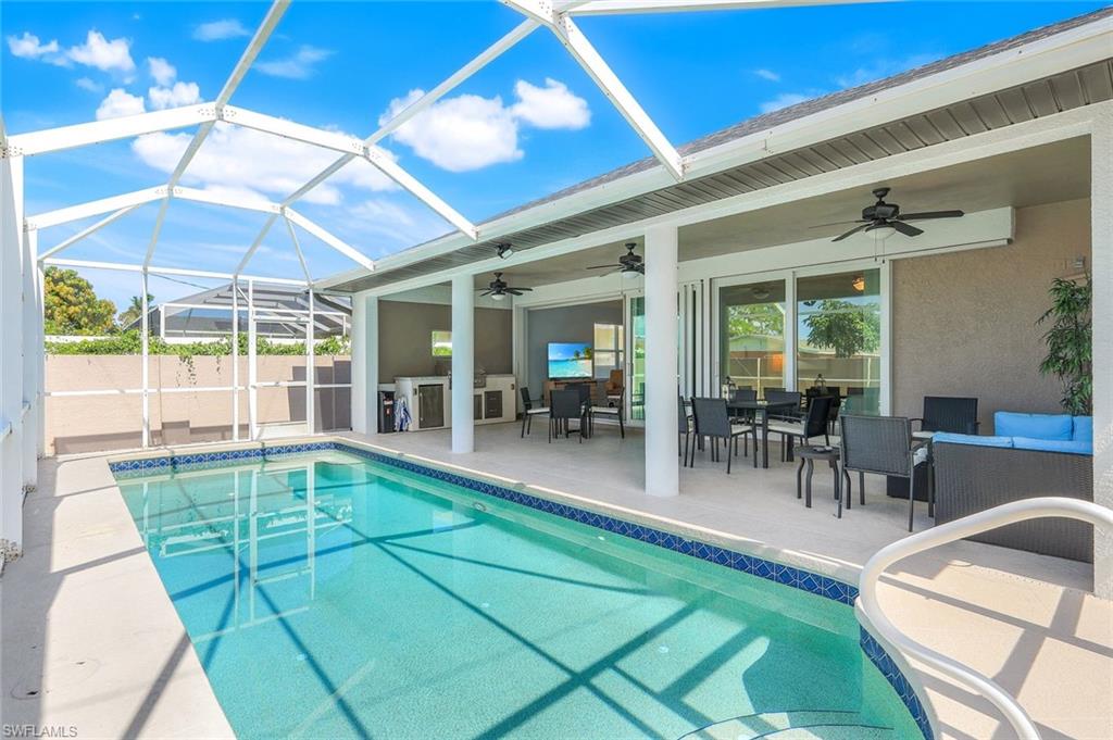 746 101st Avenue North Naples, FL 34108 - Photo 23 of 33 a view of a patio with dining table and chairs under an umbrella