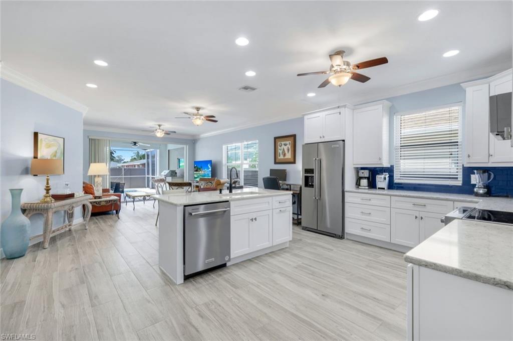 746 101st Avenue North Naples, FL 34108 - Photo 4 of 33 a kitchen with white cabinets and stainless steel appliances