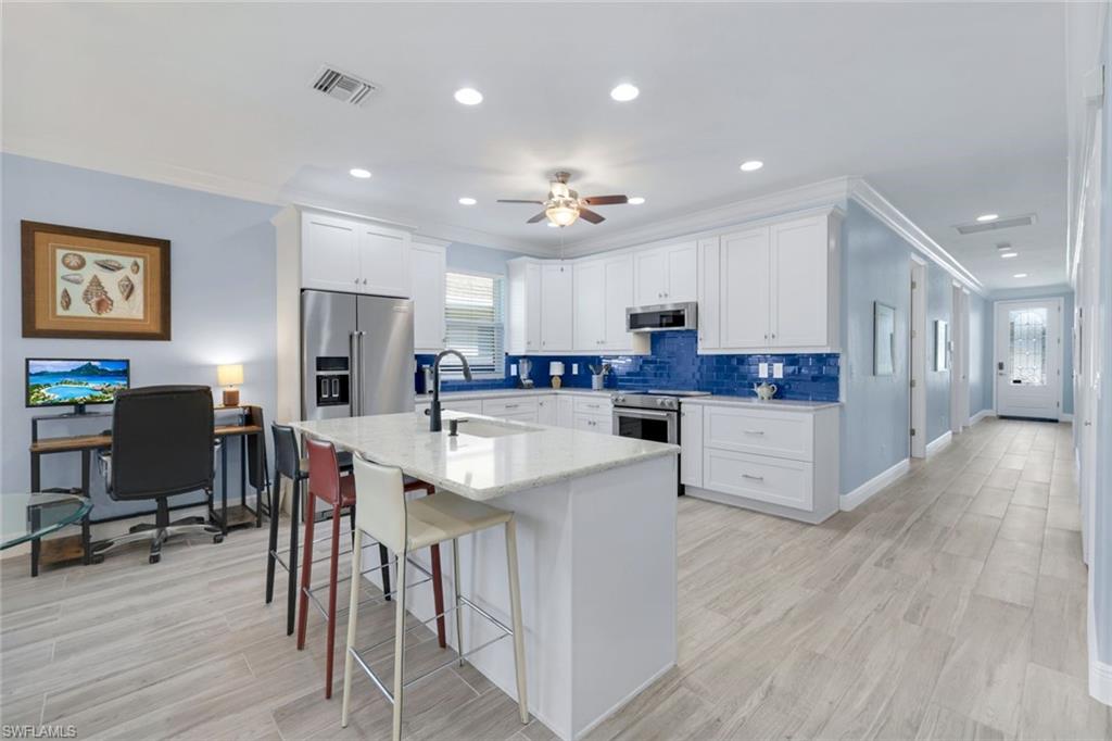 746 101st Avenue North Naples, FL 34108 - Photo 7 of 33 a kitchen with stainless steel appliances kitchen island granite countertop a refrigerator and a stove top oven