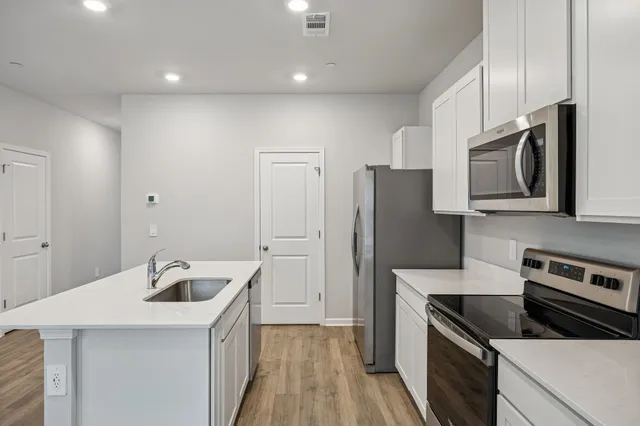 a kitchen with stainless steel appliances granite countertop a sink stove and refrigerator