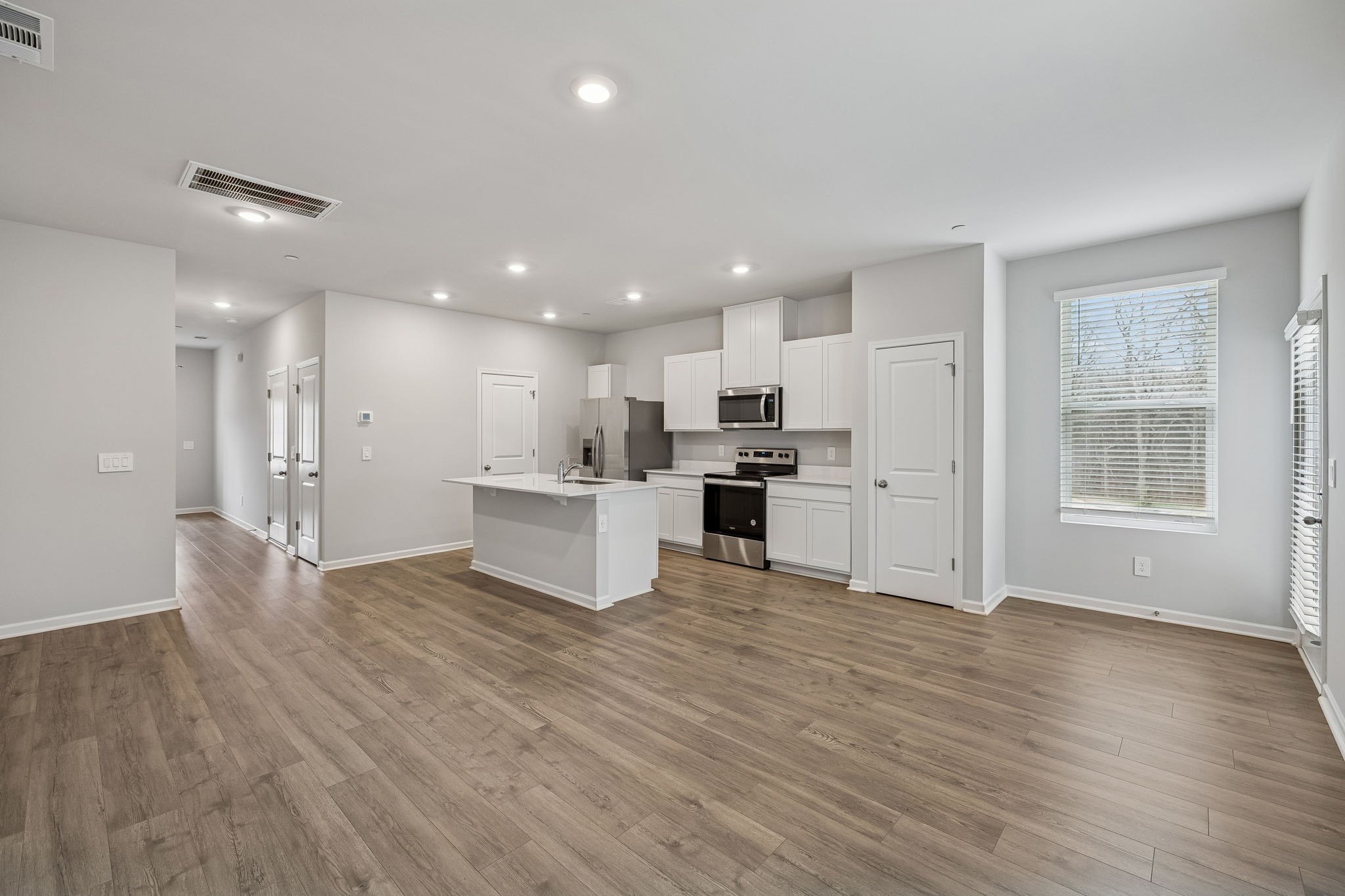 174 Mackenzie Way Lewisburg, TN 37091 - Photo 13 of 33 a view of kitchen with kitchen island wooden floor refrigerator and white cabinets