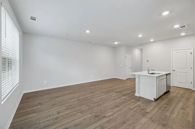 a view of a kitchen with wooden floor and window