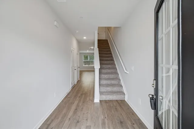 a view of a hallway with wooden floor and staircase