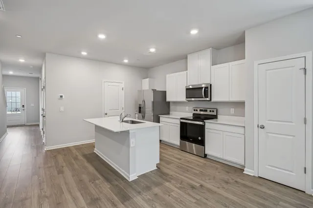 a kitchen with a sink stainless steel appliances and white cabinets