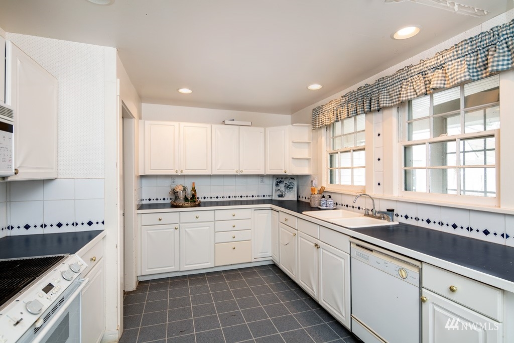 5435 Sand Road Bellingham, WA 98226 - Photo 27 of 38 a large white kitchen with a sink and cabinets
