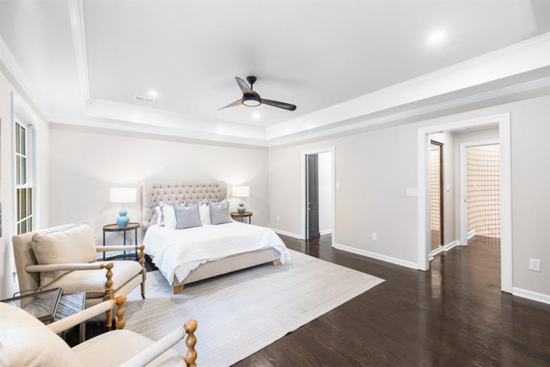 650 Moores Mill Road Northwest, Unit 11 Atlanta, GA 30327 - Photo 17 of 31 a bedroom with a bed and wooden floor