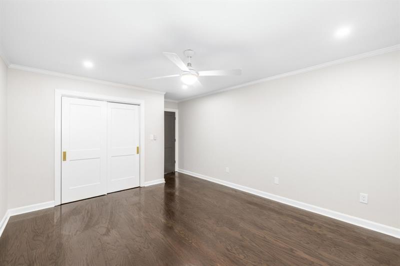 650 Moores Mill Road Northwest, Unit 11 Atlanta, GA 30327 - Photo 24 of 31 an empty room with wooden floor and a ceiling fan
