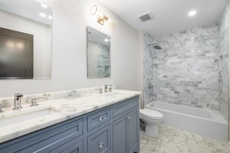 650 Moores Mill Road Northwest, Unit 11 Atlanta, GA 30327 - Photo 25 of 31 a bathroom with a granite countertop sink toilet mirror and bathtub