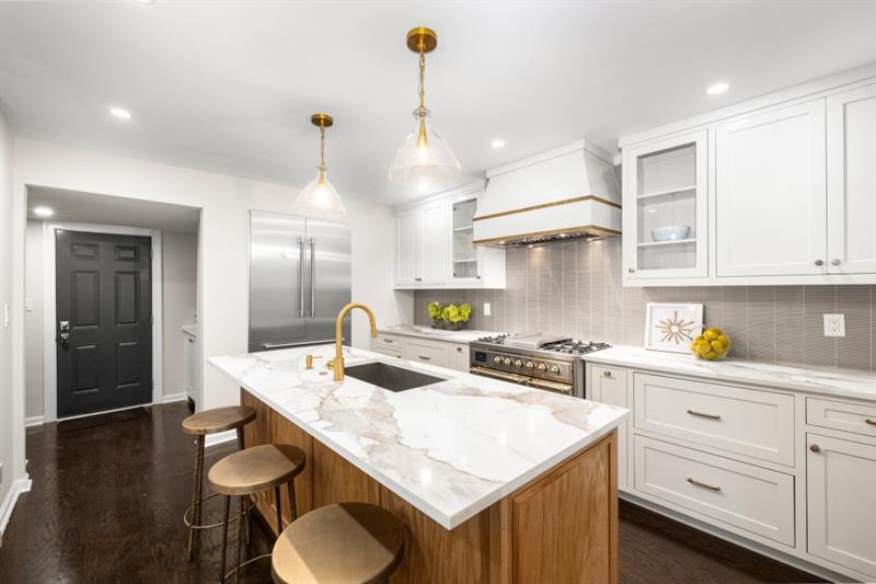 650 Moores Mill Road Northwest, Unit 11 Atlanta, GA 30327 - Photo 10 of 31 a kitchen with a stove a refrigerator a sink a dining table and chairs