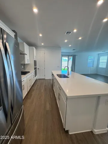 a kitchen with stainless steel appliances a refrigerator and a stove top oven