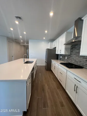 a large kitchen with stainless steel appliances sink a microwave and cabinets