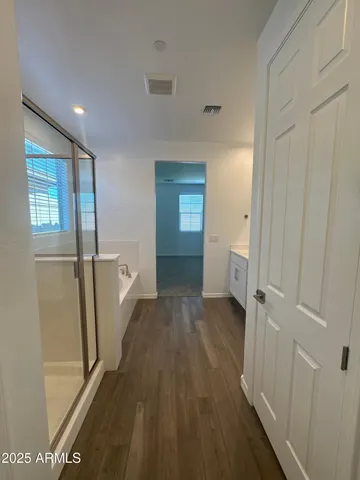 a view of a hallway with wooden floor and closet area