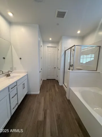 a spacious bathroom with a granite countertop sink a mirror and a bathtub