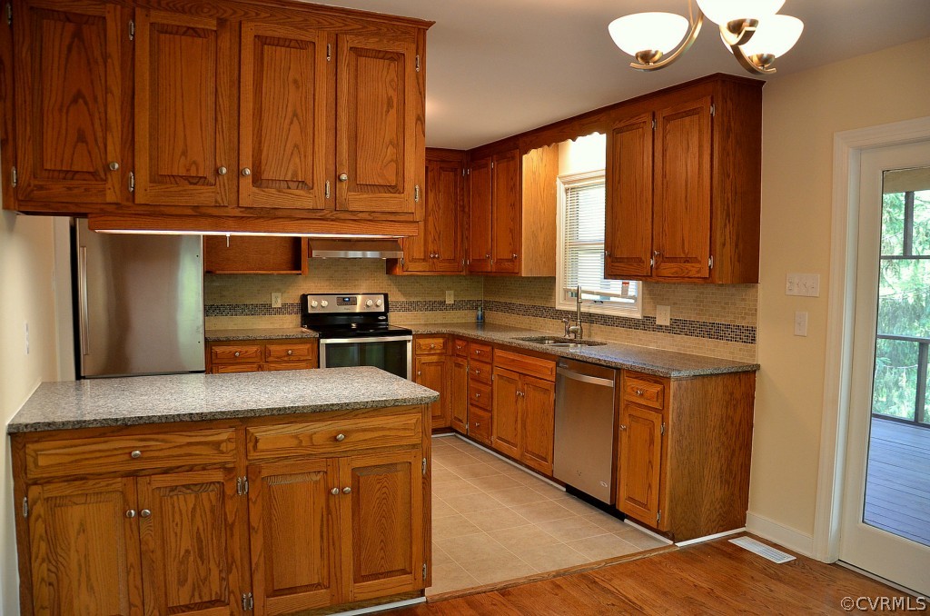 4940 Windsor Road Sandston, VA 23150 - Photo 6 of 22 a kitchen with stainless steel appliances granite countertop a sink dishwasher stove and cabinets with wooden floor