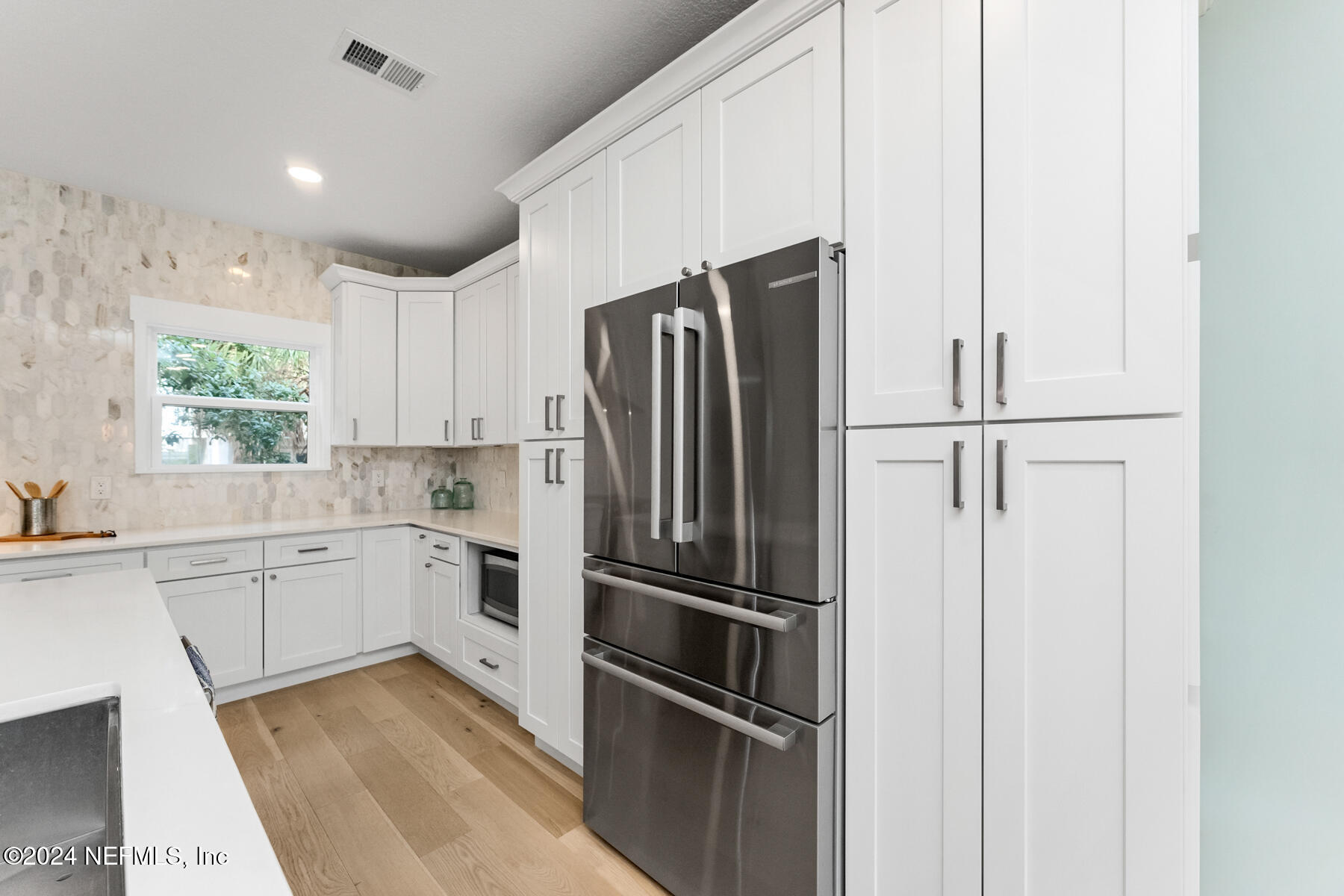 1850 Beach Avenue Atlantic Beach, FL 32233 - Photo 8 of 52 a kitchen with a refrigerator stainless steel appliances wooden floor and window
