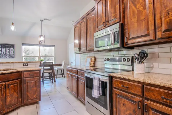a kitchen with stainless steel appliances granite countertop a sink and cabinets
