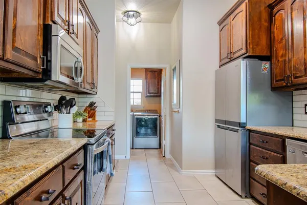 a kitchen with stainless steel appliances granite countertop a refrigerator and a sink