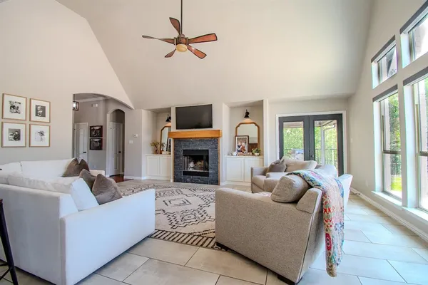 a living room with furniture a fireplace and a flat screen tv